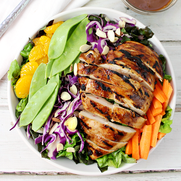 Salade de poulet asiatique dans un bol blanc avec des légumes frais.