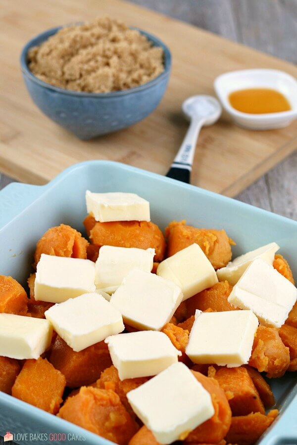 Learn how to make candied yams for your next family meal, it's so simple! This candied sweet potatoes recipe is easy and delicious! This photo shows that the next step for how to make candied yams is layering on the butter!