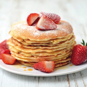 Pancakes au babeurre moelleux servis avec fraises et sirop d'érable